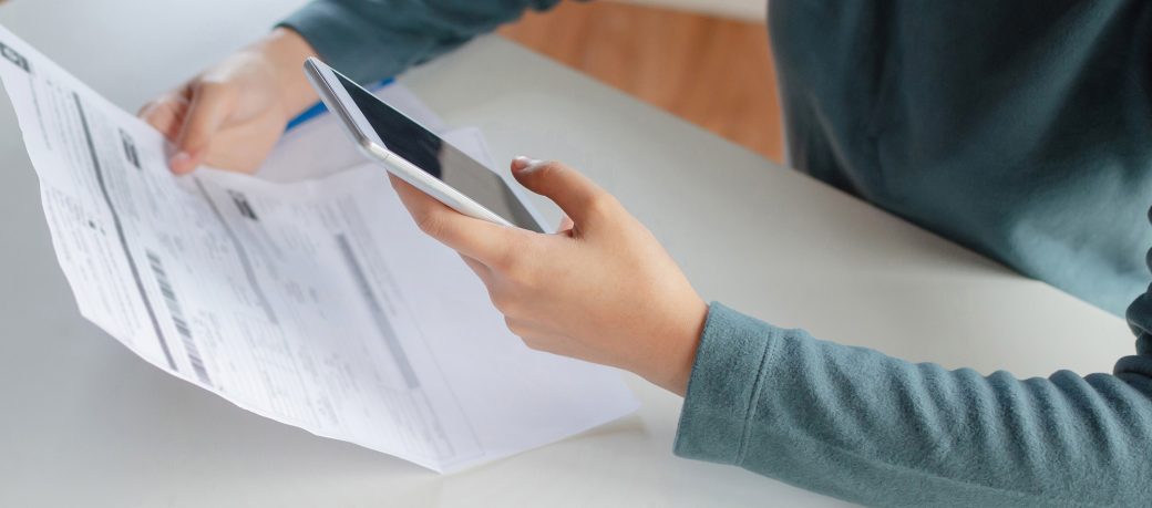 Woman looking at bills on phone